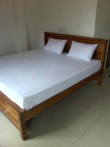 a bed with two white pillows on top of it at Sumudu Villa in Hikkaduwa
