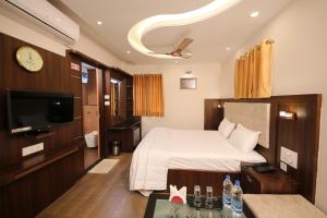 a hotel room with a bed and a tv at Le Emerald Residency in Tambaram