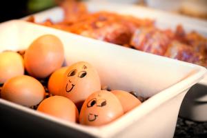 two eggs with faces drawn on their heads next to other eggs at Best Western Plus Palatin Kongresshotel in Wiesloch