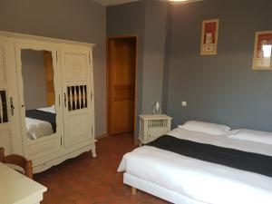 a bedroom with two white beds and a cabinet at L'ALCOVE HOTEL RESTAURANT in Villematier