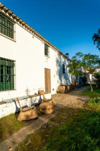 um grupo de cadeiras sentadas fora de um edifício em Casa de los Curas, chimenea 2 Hab 4 Pers Max em Puerto de la Laja