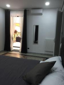 ナポリにあるMB95 - Mezzocannone Luxurious Bed&Breakfastのベッドルーム1室(ベッド1台付)、窓(カーテン付)