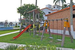 un parque con un parque infantil con un tobogán rojo en Canadian Resort Veracruz en Costa Esmeralda
