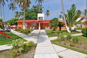 una casa con techo rojo y parque infantil en Canadian Resort Veracruz, en Costa Esmeralda