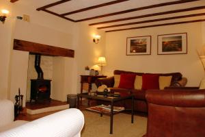 a living room with a couch and a fireplace at Hillocks Cottage, Kniveton in Kniveton