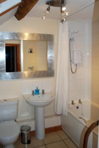 a bathroom with a sink and a toilet and a tub at Hillocks Cottage, Kniveton in Kniveton