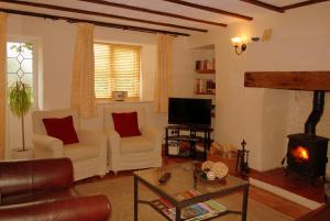 a living room with a couch and a fireplace at Hillocks Cottage, Kniveton in Kniveton