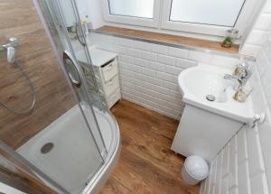 La salle de bains est pourvue d'une douche, de toilettes et d'un lavabo. dans l'établissement Apartament Nadmorski - NoclegiSopot, à Sopot