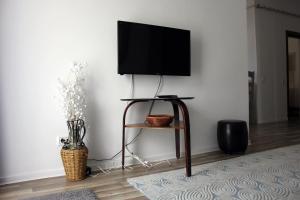 a flat screen tv on a stand in a living room at Happy Holiday Apartments in Predeal