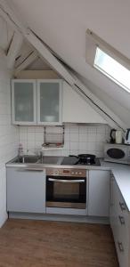 a kitchen with white cabinets and a stove top oven at zum Fischerhaus in Konstanz