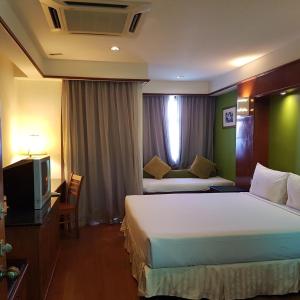 a hotel room with two beds and a television at Tokido Private Water Chalet PD in Port Dickson