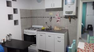 una pequeña cocina con fogones y fregadero en Departamento MT 2 Barrio Jardín en Córdoba