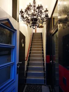 a hallway with a staircase with a chandelier at Ferienwohnung "Kleine Nixe" in Jever