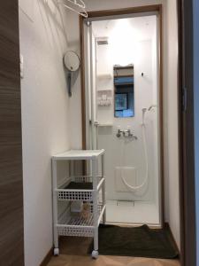 uma pequena casa de banho com um chuveiro e um lavatório. em Nono teru Narita em Narita