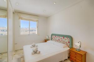 a white bedroom with a bed and a window at Villas Guzman - Apartamento Cap Dor in Moraira