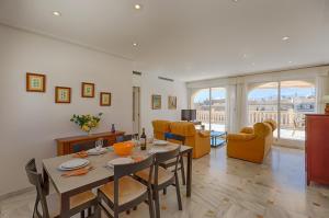 a dining room and living room with a table and chairs at Villas Guzman - Apartamento Cap Dor in Moraira