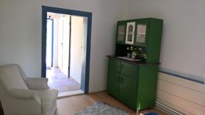 une armoire verte et une chaise dans une pièce dans l'établissement Altes Pfarrhaus, à Neuenkirchen auf Rugen