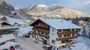 a ski lodge in the mountains with snow on the roof at Hotel Aquamarin in Bad Mitterndorf