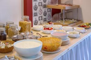 a buffet with bowls of food on a table at Hotel Aquamarin in Bad Mitterndorf