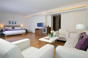 a living room with white furniture and a bed at O Monot Boutique Hotel Beirut in Beirut