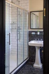 a bathroom with a glass shower and a sink at The Princess Victoria in London
