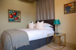 a bedroom with a bed and a table with a lamp at The Princess Victoria in London