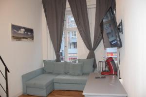 Una sala de estar con un sofá y un televisor. en Kudamm Apartments, en Berlín