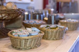 three baskets sitting on top of a counter with bread at Hotel Aquamarin in Bad Mitterndorf