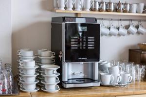 a coffee machine sitting on a counter next to cups at Hotel Aquamarin in Bad Mitterndorf