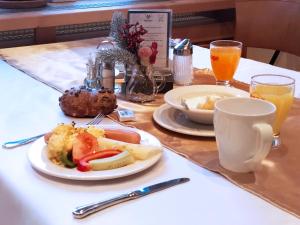 a table with two plates of food and two glasses of orange juice at Hotel Aquamarin in Bad Mitterndorf