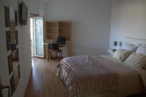 a bedroom with a bed and a desk with a computer at Ericeira Sunset Apartment in Ericeira