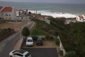 two cars parked in a parking lot next to the ocean at Ericeira Sunset Apartment in Ericeira