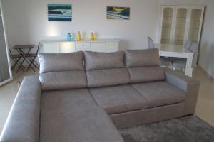 a brown couch in a living room with a table at Ericeira Sunset Apartment in Ericeira