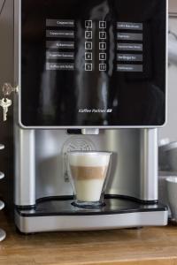 a coffee maker with a cup of coffee at Hotel Aquamarin in Bad Mitterndorf