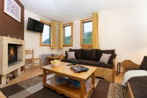 Una sala de estar con un sofá y una chimenea. en Madame Vacances les Chalets des Alpages, en La Plagne