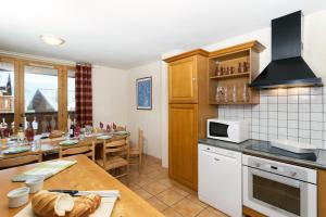 a kitchen with a table and a dining room at Madame Vacances les Chalets des Alpages in La Plagne