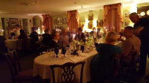 a group of people sitting around a table with wine glasses at Alnwick Lodge West Cawledge Park in Shilbottle