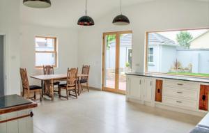 uma cozinha e sala de jantar com mesa e cadeiras em The Nore River House em Kilkenny