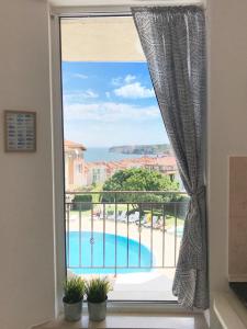 a window with a view of a swimming pool at Apartament Rose in Sozopol
