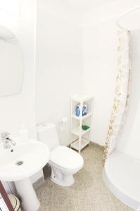 a white bathroom with a toilet and a sink at Apartament Rose in Sozopol