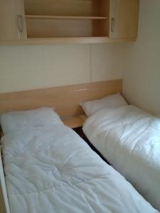 dos camas sentadas una al lado de la otra en una habitación en Caravan hire Winthorpe Skegness, en Skegness