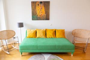 a green couch with yellow pillows in a room at A Twist of Lime in Moravske Toplice