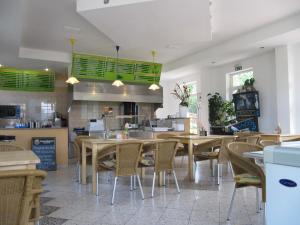 ein Restaurant mit Holztischen und -stühlen und einer Küche in der Unterkunft Hotel am Bahnhof in Coppenbrügge