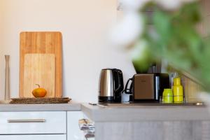 A Twist of Lime في مورفسكه تيبليتسه: منضدة مطبخ مع آلة صنع القهوة وبرتقال عليها