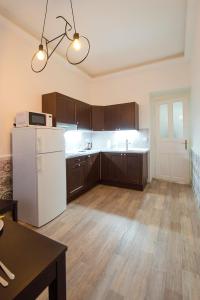 a kitchen with a white refrigerator and wooden cabinets at Modern Apartment Navratilova 16 in Prague