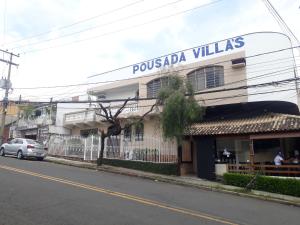 un bâtiment avec un panneau indiquant les villas pussula dans l'établissement Pousada Villas, à Sorocaba