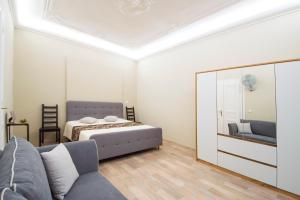 ein Schlafzimmer mit einem Bett, einem Sofa und einem Spiegel in der Unterkunft Modern Apartment Navratilova 16 in Prag