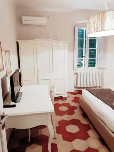 a bedroom with a bed and a desk with a laptop at Toselli Suite Apartment in Pisa