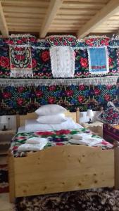 a bedroom with a bed with blankets and pillows at Sub Creasta Cocosului in Breb