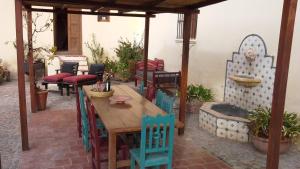 eine Terrasse mit einem Holztisch und Stühlen in der Unterkunft Casa del Tejedor in Cachí